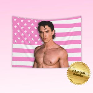 May include: A rectangular wall tapestry featuring a pink and white American flag pattern with a centred photographic portrait of a shirtless person with dark hair wearing a thin gold chain necklace. A gold circular seal reads ORIGINAL DESIGN.