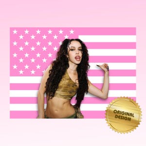 Può includere: Un design della bandiera americana rosa e bianca con una donna con un top corto mimetico e lunghi capelli ricci scuri. Un sigillo d'oro con le parole "ORIGINAL DESIGN" è nell'angolo in basso a destra.