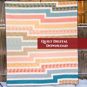 Op de afbeelding: Een kleurrijk quilt met een geometrisch patroon van horizontale strepen en gehoekte lijnen. De quilt is gemaakt van verschillende stoffen in tinten blauw, roze, geel en bruin. De quilt hangt aan een houten hek en de tekst "QUILT DIGITAL DOWNLOAD" wordt weergegeven op een rode banner.