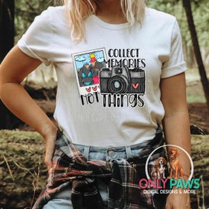 May include: White t-shirt featuring a graphic of a camera and a photo booth with the text "Collect Memories Not Things".