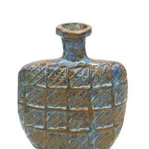 Könnte beinhalten: Eine blaue und braune Keramikvase mit geometrischem Muster. Die Vase hat einen breiten Boden und einen schmalen Hals.