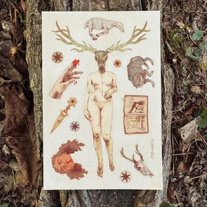 May include: A sticker sheet featuring a central figure with a deer skull head and large antlers, surrounded by illustrations of a lamb, a wolf, a hand with bleeding fingers, an open book, a golden dagger, a human face, and a deer skull.