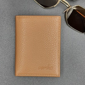 May include: A brown leather wallet with the word "verka" embossed on the front.
