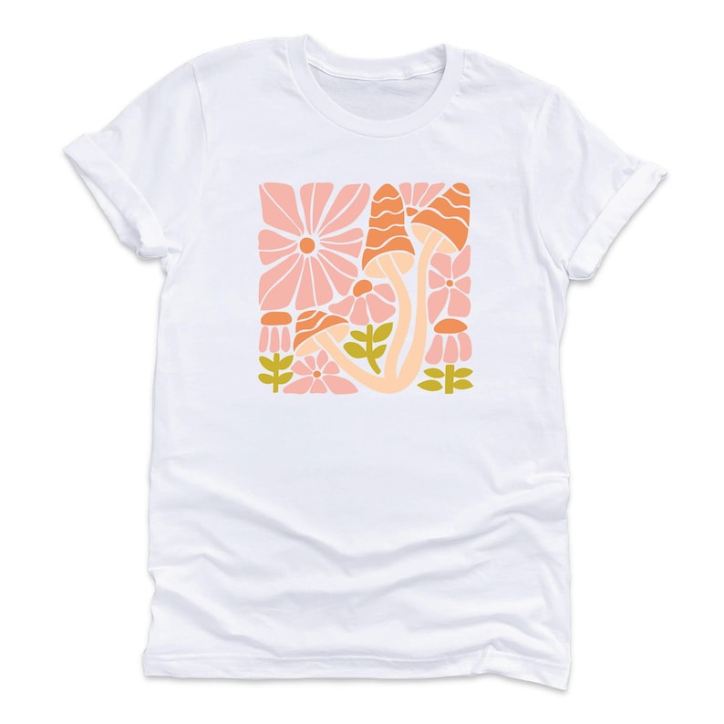May include: A white t-shirt with a graphic print of pink and orange flowers and mushrooms in a retro style.