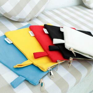 a group of four zippered pouches sitting on top of a couch