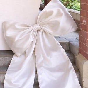 May include: A white ceramic mug with a black handle and the text "But First, Coffee" in a handwritten style. The mug is on a white surface. The mug is likely for hot beverages.