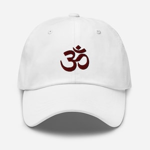 Puede incluir: Gorra de béisbol blanca con un símbolo Om bordado en granate.