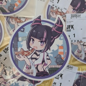 May include: A round sticker featuring a cartoon illustration of a girl with purple hair and a pink headband eating pizza. The sticker has a blue border and the text "Thank You" is printed on the bottom. The sticker is on a yellow surface.