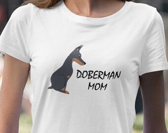 May include: White t-shirt with a black and brown Doberman Pinscher illustration and the text "Doberman Mom".