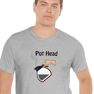 May include: A heather grey t-shirt with a graphic of a coffee pot and the text "Pot Head" printed on the front.