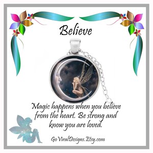 May include: A silver necklace with a round pendant featuring a crescent moon with a fairy sitting on it. The pendant has a starry night sky background. The necklace is on a white background with the text "Believe" and a quote about magic happening when you believe from the heart. The text "Go Viral Designs. Etsy.com" is at the bottom of the image.