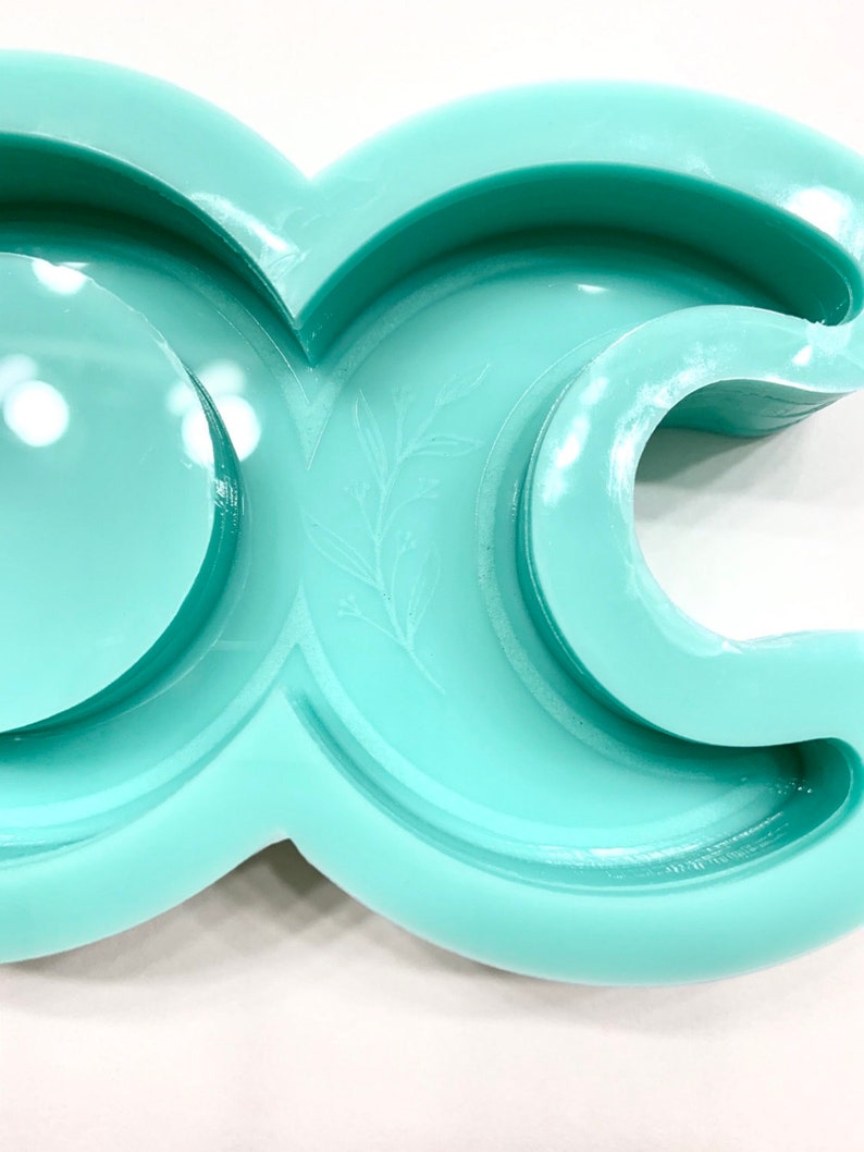 Puede incluir: Un molde de silicona verde claro con forma de media luna con un peque&ntilde;o dise&ntilde;o de hoja. El molde est&aacute; dise&ntilde;ado para hacer manualidades de resina.