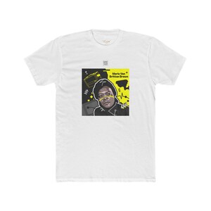 May include: White t-shirt with a black and yellow graphic of Marie Van Brittan Brown, a pioneer in home security systems. The graphic includes a stylized image of a television and other geometric shapes.