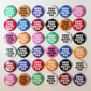 May include: A selection of circular badges in a variety of colours, each bearing the text "DOUG FORD HATES YOU" in a clear, sans-serif font. The badges are arranged in a grid formation.