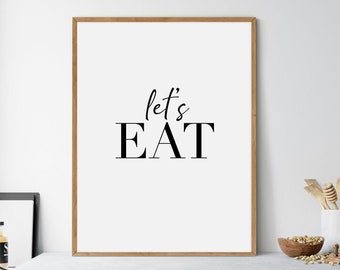 May include: A framed print with the text "let's EAT" in black lettering on a white background. The frame is a light brown wood.
