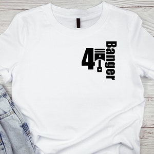 Puede incluir: Camiseta blanca con un gráfico negro de un pistón y el texto "4 Banger" impreso en la parte delantera.