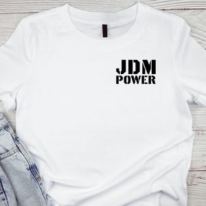 May include: White t-shirt with black text that reads "JDM POWER" on the front.