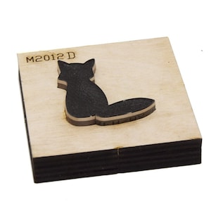 May include: A wooden die-cutting template with the code M2012D and a silhouette of a fox facing away from the viewer.