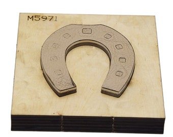 May include: A wooden craft die with the number M5971 printed on it. The die is shaped like a horseshoe with a cutout in the center.