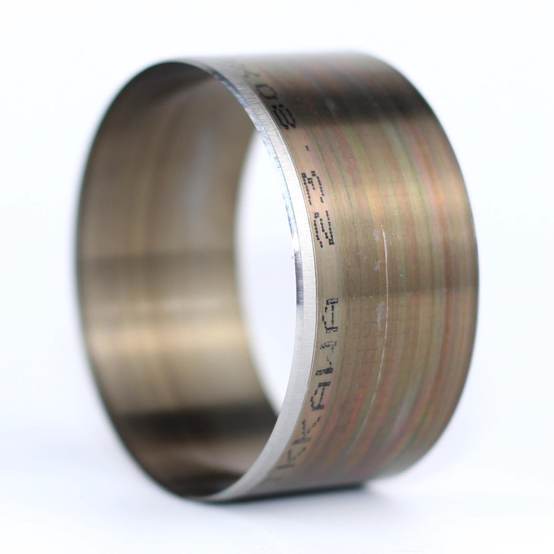May include: A silver metal ring with a black inscription that reads "K.C. FIVF 502".