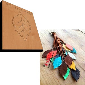 May include: A wooden block with the text "XF464 叶子挂" and a leaf design. A leather keychain with a tassel and multiple colorful leather leaves attached.