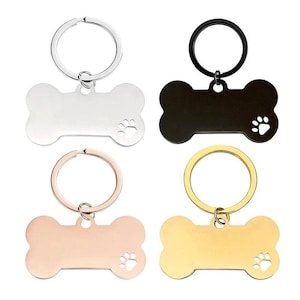 Peut inclure: Quatre porte-clés en forme d'os de chien dans différentes couleurs : argent, noir, or rose et or. Chaque porte-clés est orné d'une empreinte de patte et d'un anneau brisé.