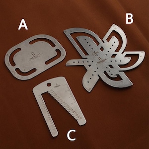 May include: Three metal sewing tools, including a ruler with markings in inches, a curved ruler with markings in inches, and a small ruler with markings in millimeters. The tools are made of silver metal and have the text "Nattools" printed on them.