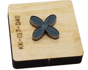 Puede incluir: Una herramienta de corte de madera con forma de flor de cuatro pétalos. La flor es de color gris oscuro con un borde marrón, sobre una base de madera clara. El texto "KK-017-D40" está impreso en la madera.