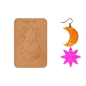 Puede incluir: Una plantilla de madera para hacer pendientes con una estrella, una luna creciente y un pequeño círculo para un agujero. La plantilla está etiquetada como "YY6079".