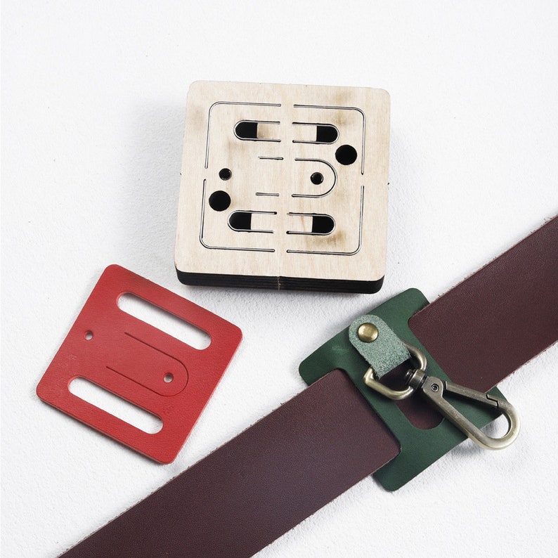 May include: A set of leather craft tools including a red leather punch, a green leather punch, and a wooden template with cutouts for different shapes.