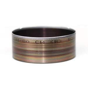May include: A silver metal ring with a textured surface and black markings that read "OH-80 CW <RX> B".