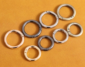 Può includere: Assortimento di sei portachiavi in metallo in diverse finiture, tra cui oro, argento e nero. Gli anelli sono tutti chiusi e hanno una chiusura a molla.