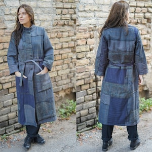 Könnte beinhalten: Ein langer Patchwork-Mantel mit Gürtel. Der Mantel ist aus verschiedenen Blautönen und Grautönen gefertigt und hat einen Kragen und Taschen.