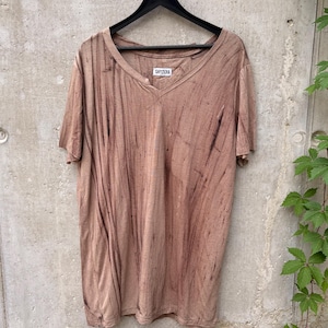 May include: A short-sleeved V-neck t-shirt in a muted brown color with a vertical black streaked pattern. The garment features a white interior neck label with the black text SHYZUXA and is displayed on a black plastic hanger.