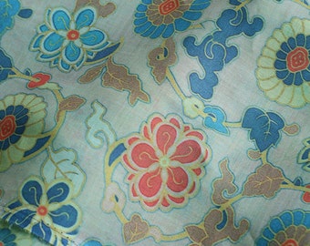 Könnte beinhalten: Ein hellblauer Stoff mit einem floralen Muster. Die Blumen sind in Blautönen, Rot und Gold gehalten. Der Stoff hat einen dezenten Glanz.