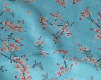 Könnte beinhalten: Ein hellblauer Stoff mit einem weißen und rosafarbenen Blumenmuster. Der Stoff zeigt ein sich wiederholendes Muster aus Kirschblüten mit roten Akzenten und Schmetterlingen.