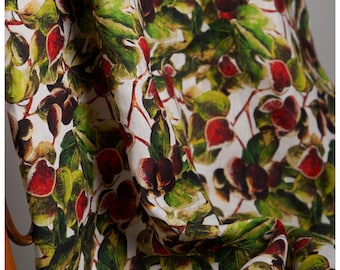 May include: White fabric with a repeating pattern of green leaves and red and brown figs.