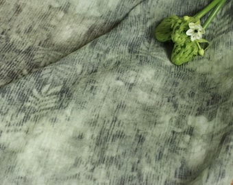 Puede incluir: Tela verde con un patrón sutil y una flor verde claro y blanca.