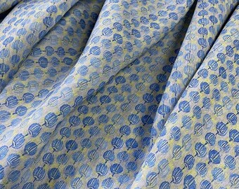 May include: A close-up of a fabric with a repeating pattern of blue and yellow stylized flowers. The fabric has a light gray background.