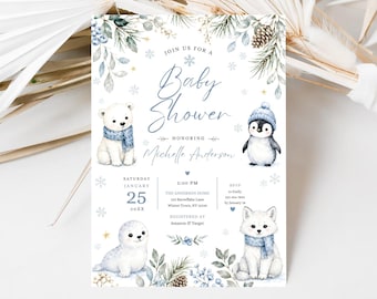 Peut inclure: Une carte d'invitation pour baby shower blanche avec des illustrations aquarelles d'un ours polaire, d'un manchot, d'un phoque et d'un renard arctique portant des écharpes et bonnets bleus, décorée de branches de pin, pommes de pin et flocons.