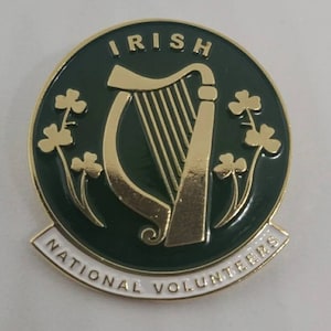 Può includere: Uno spillo in smalto dorato e verde con un'arpa e trifogli. Lo spillo riporta la scritta "Irish National Volunteers".