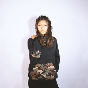 May include: A black hooded sweatshirt with a camouflage print pocket. The hood is lined with camouflage fabric.
