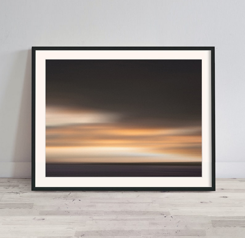 May include: Abstract art print of a blurred sunset over a body of water. The colors are mostly shades of orange, yellow, and brown.