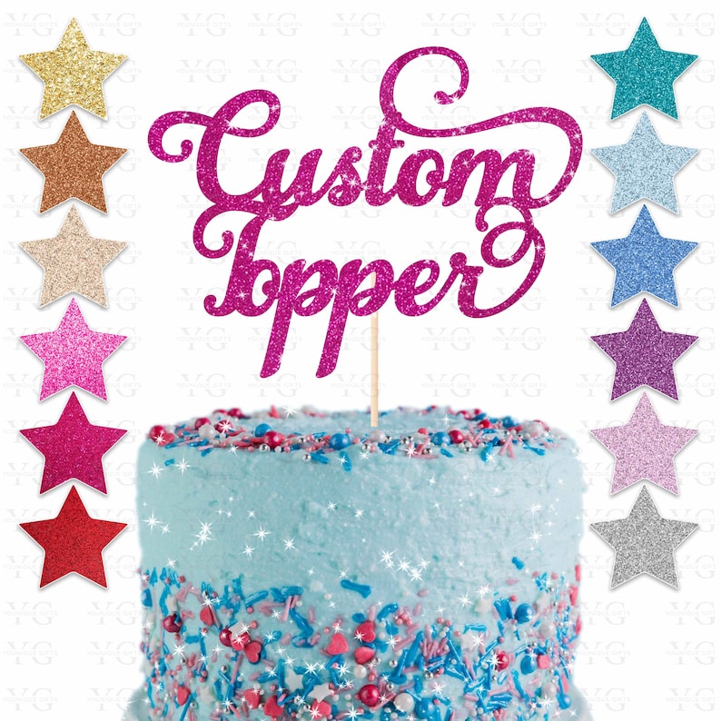 K&ouml;nnte beinhalten: Ein rosa glitzernder Tortendekor mit den Worten "Custom Topper" in einer kursivschrift. Der Dekor befindet sich auf einem blau gefrosteten Kuchen mit bunten Streuseln.