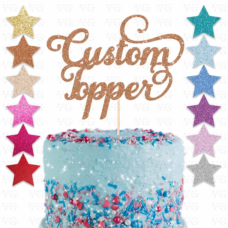 K&ouml;nnte beinhalten: Ein goldener Glitzer-Kuchentopper mit den Worten "Custom Topper" in einer kursiv geschriebenen Schrift. Der Topper befindet sich auf einem blau gefrosteten Kuchen mit bunten Streuseln. Das Bild zeigt auch eine Vielzahl von Glitzersternen in verschiedenen Farben.