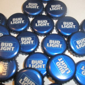 May include: A collection of blue bottle caps with the words "Bud Light" printed in white on each cap.