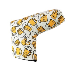 May include: White golf club head cover with a pattern of yellow beer mugs with foam on top.