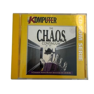 Op de afbeelding: Een gele CD-ROM-hoes met de titel "The C.H.A.O.S. Continuum" in grote, vette letters. De cover toont een metalen hand die uitreikt, met een sciencefiction-scène op de achtergrond. Het woord "KOMPUTER" staat bovenaan.