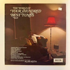 Op de afbeelding: Vintage vinyl platenhoes met de titel "The World of Your Hundred Best Tunes Vol. 4". De hoes toont een stel in een kamer met een rode lamp. Het album bevat fragmenten van klassieke muziek.