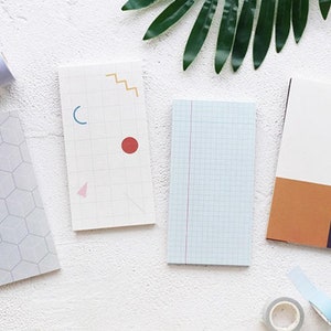 May include: Four different patterned memo pads with white backgrounds. The pads have geometric patterns in blue, red, orange, and brown.